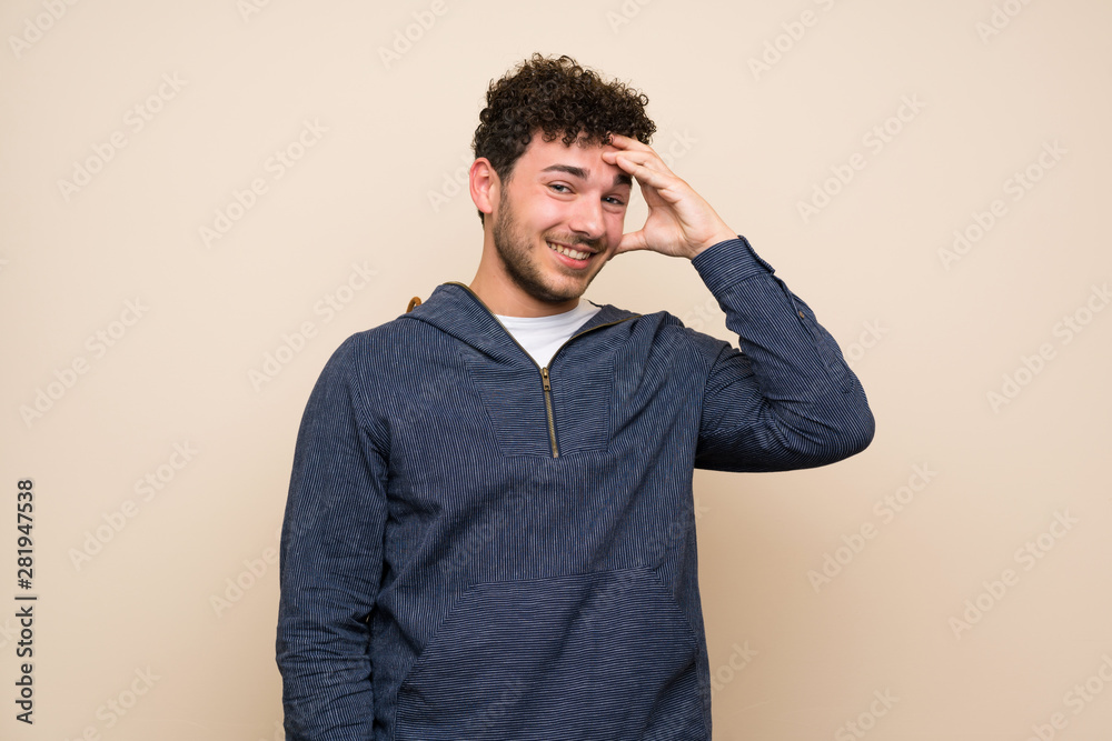 Man with curly hair over isolated wall has just realized something and has intending the solution