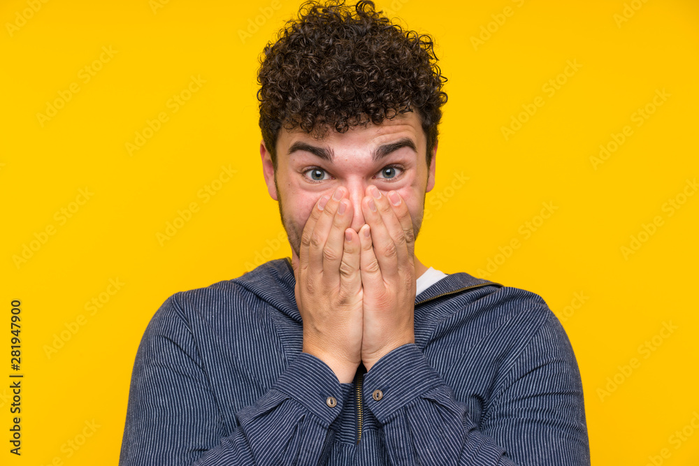 Young man over isolated yellow wall with surprise facial expression Young man over isolated yellow wall with surprise facial expression