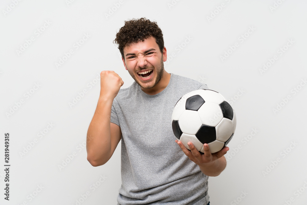 Man with curly hair over isolated wall holding a soccer ball Man with curly hair over isolated wall holding a soccer ball