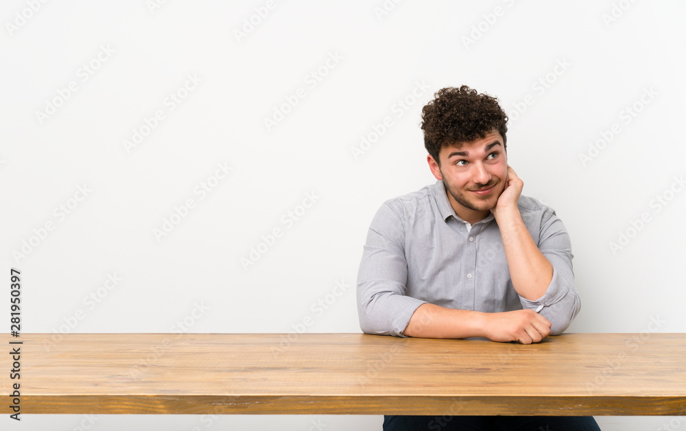 Young man with a table thinking an idea Young man with a table thinking an idea