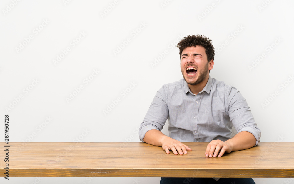 Young man with a table shouting to the front with mouth wide open Young man with a table shouting to the front with mouth wide open