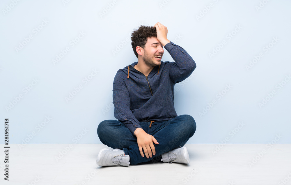 Young man sitting on the floor has realized something and intending the solution Young man sitting on the floor has realized something and intending the solution