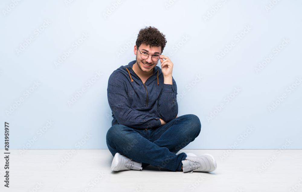Young man sitting on the floor with glasses and happy Young man sitting on the floor with glasses and happy
