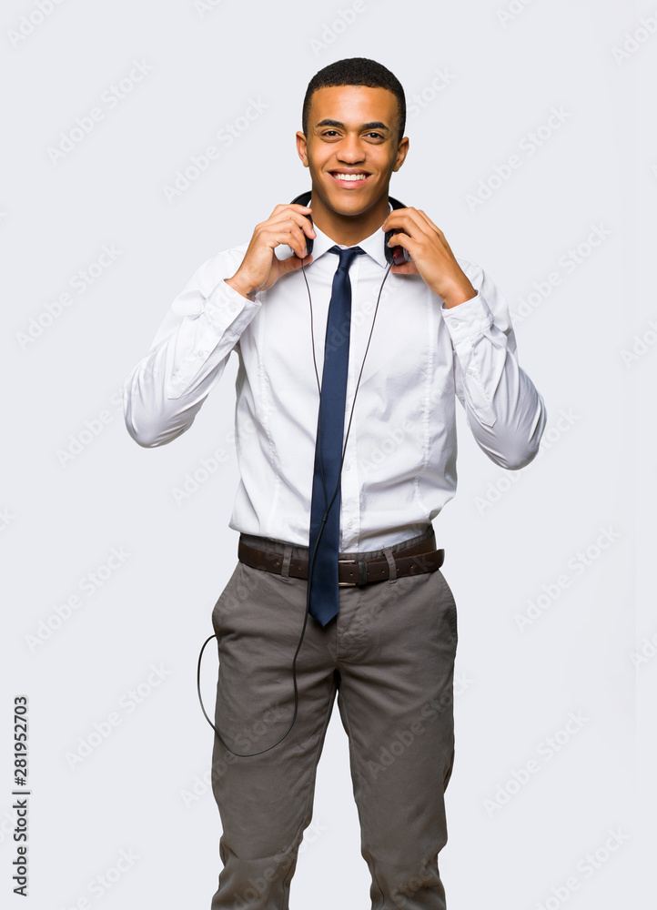 Young afro american businessman with headphones on isolated background Young afro american businessman with headphones on isolated background