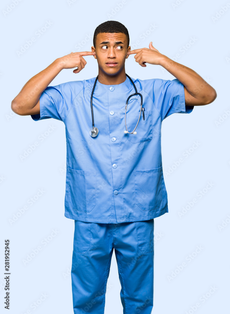 Surgeon doctor man covering both ears with hands on isolated background Surgeon doctor man covering both ears with hands on isolated background