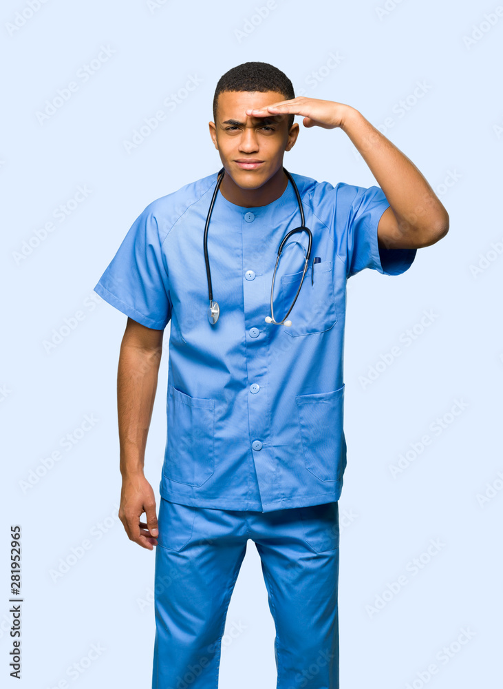 Surgeon doctor man looking far away with hand to look something on isolated background Surgeon doctor man looking far away with hand to look something on isolated background