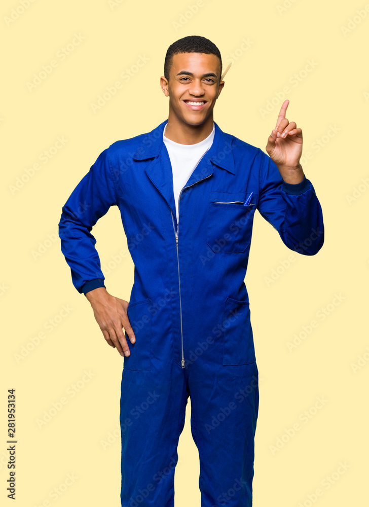 Young afro american worker man showing and lifting a finger in sign of the best on isolated background Young afro american worker man showing and lifting a finger in sign of the best on isolated background