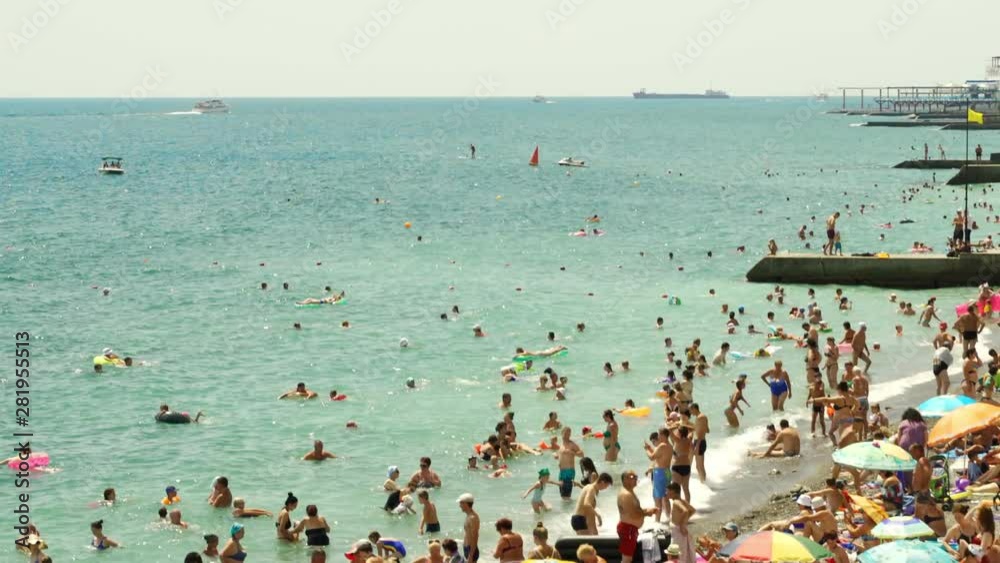 Beach in the summer a lot of people swim and have fun in the sea, boats and boats sail 4k time lapse in Yalta Beach in the summer a lot of people swim and have fun in the sea, boats and boats sail 4k time lapse in Yalta