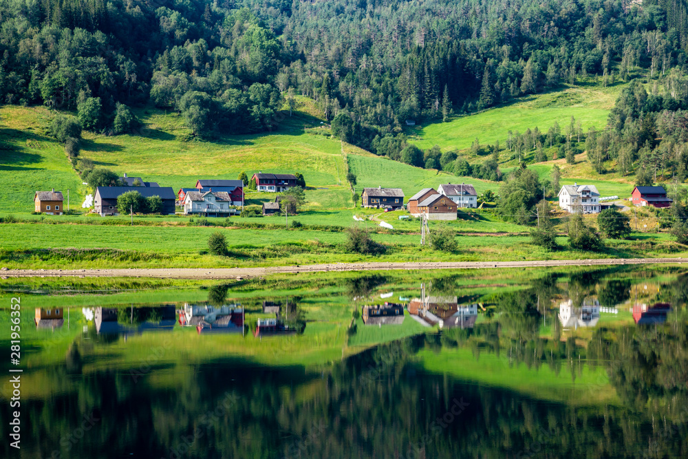 Little village along lake Vangsvatnet reflected in the water near Voss Hordaland county Norway