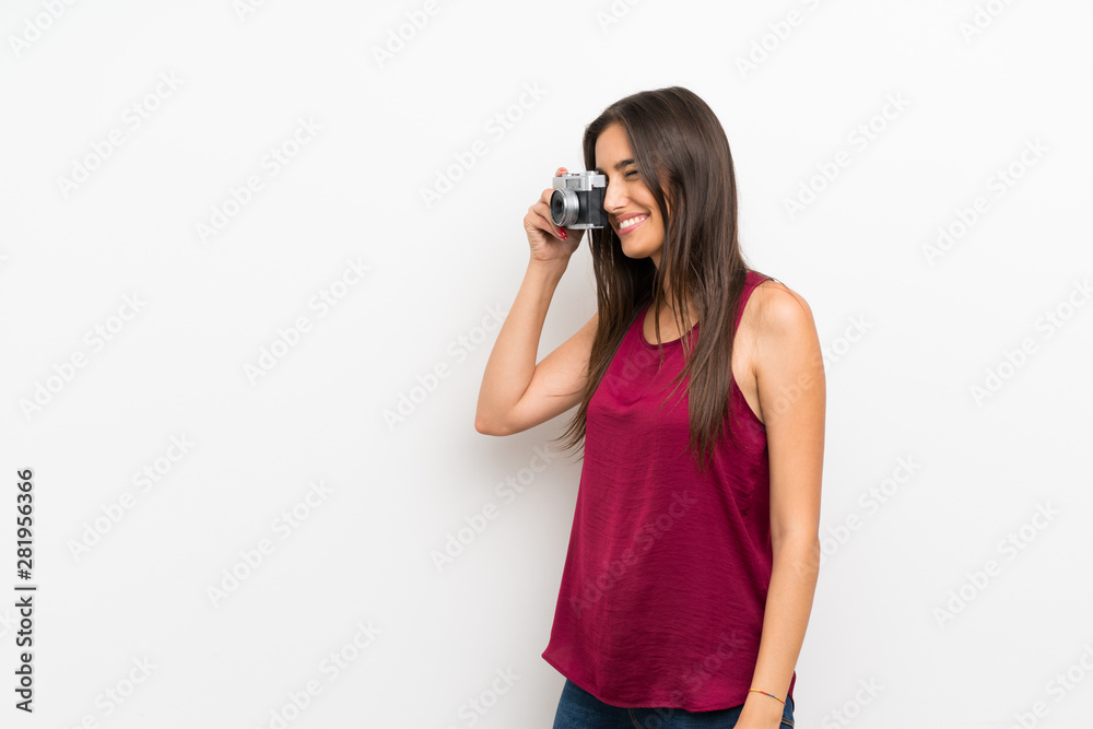 Young woman over isolated white background holding a camera Young woman over isolated white background holding a camera