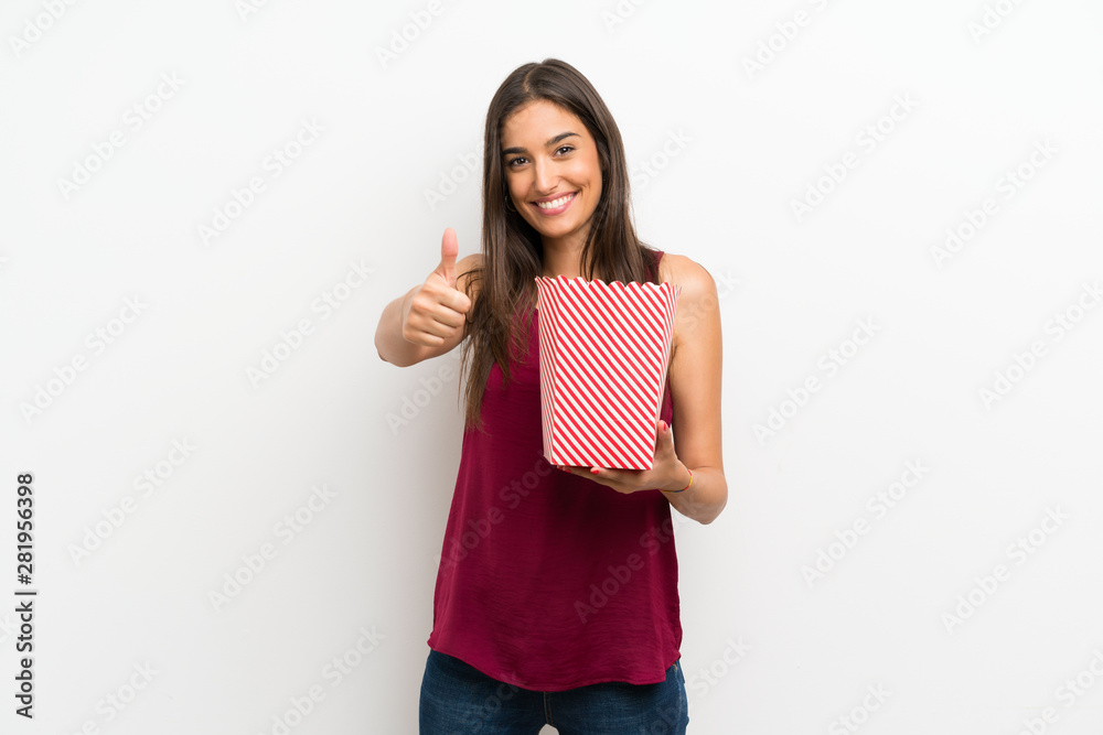 Young woman over isolated white background holding a bowl of popcorns Young woman over isolated white background holding a bowl of popcorns