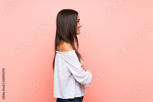 Young woman over isolated pink background in lateral position
