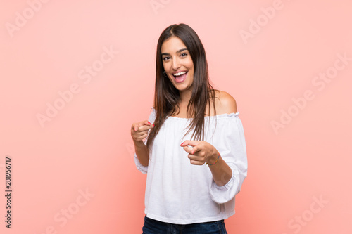 Young woman over isolated pink background pointing to the front and smiling