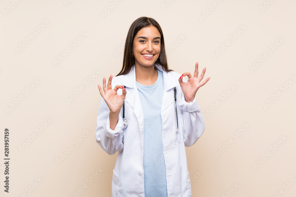 Young doctor woman over isolated background showing an ok sign with fingers Young doctor woman over isolated background showing an ok sign with fingers
