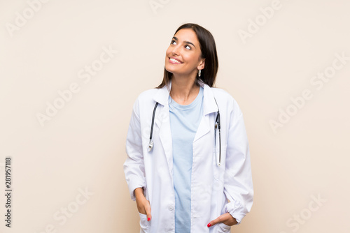 Young doctor woman over isolated background laughing and looking up