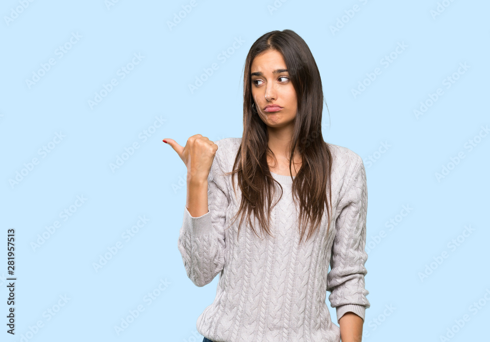 Young hispanic brunette woman unhappy and pointing to the side over isolated background Young hispanic brunette woman unhappy and pointing to the side over isolated background