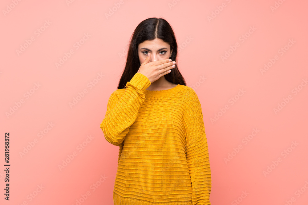 Teenager girl over isolated pink wall covering mouth with hands Teenager girl over isolated pink wall covering mouth with hands