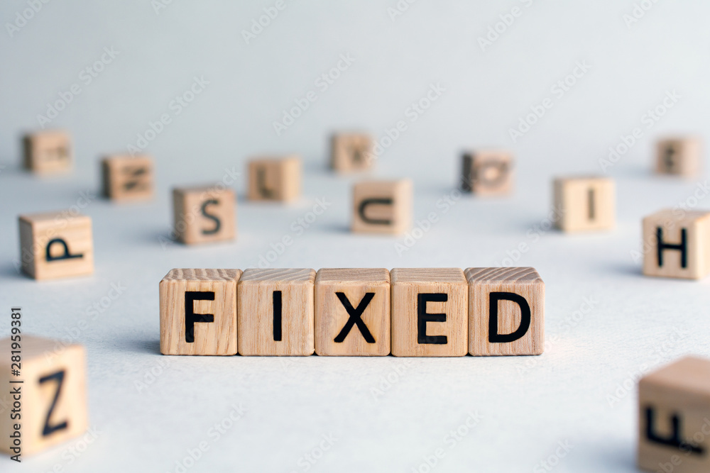 Fixed - word from wooden blocks with letters, fixed interest rates or costs  concept, random letters around, top view on wooden background - obrazy, fototapety, plakaty 