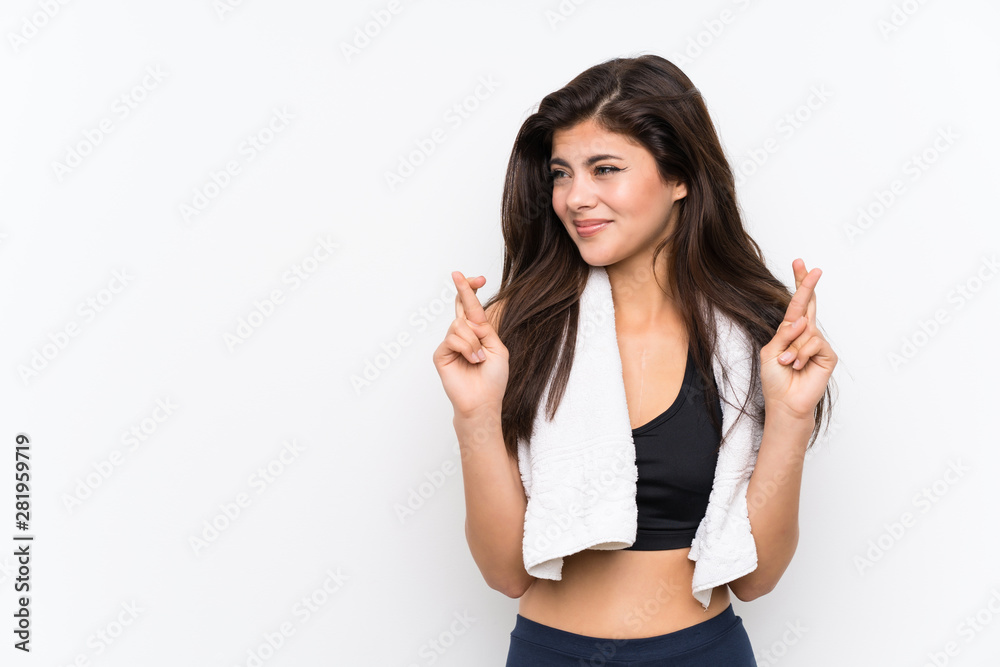 Teenager sport girl over isolated white background with fingers crossing Teenager sport girl over isolated white background with fingers crossing