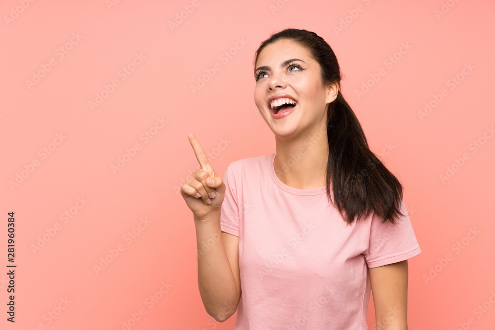 Teenager girl over isolated pink background touching on transparent screen Teenager girl over isolated pink background touching on transparent screen