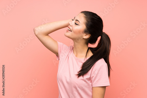 Teenager girl over isolated pink background laughing