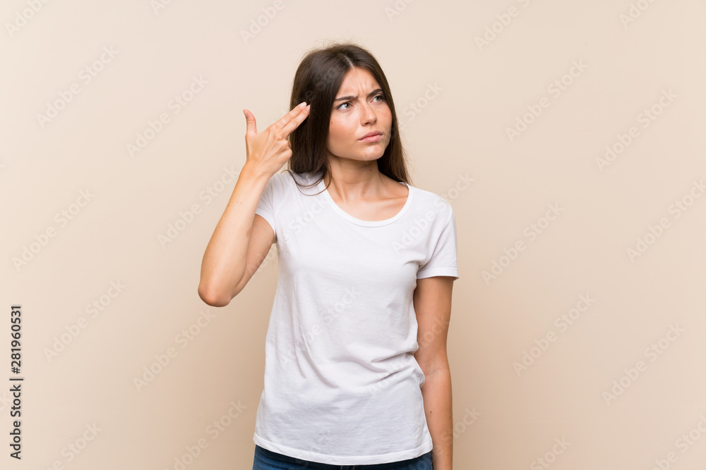 Pretty young girl over isolated background with problems making suicide gesture Pretty young girl over isolated background with problems making suicide gesture