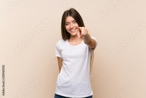 Pretty young girl over isolated background points finger at you with a confident expression