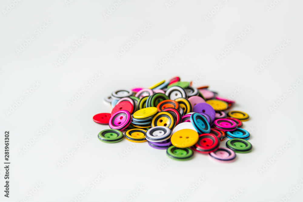 lots of colorful round buttons on white background, pile, side view