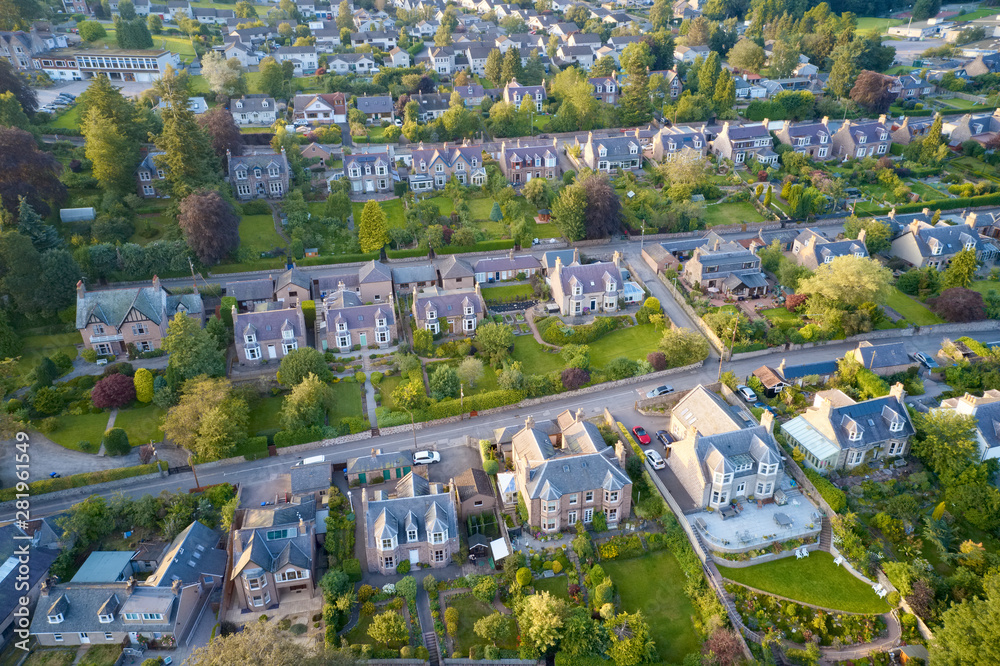 Suburban houses in row aerial view in summer illuminating gardens