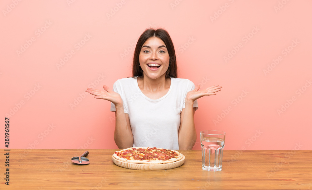 Young woman with a pizza with shocked facial expression Young woman with a pizza with shocked facial expression