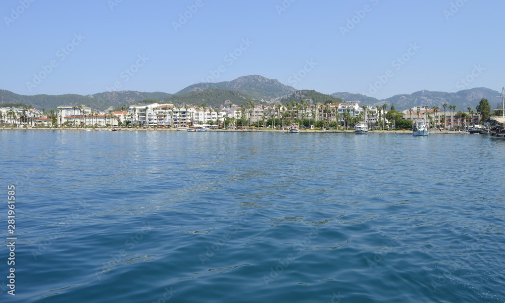 View of the embankment of the city of Marmaris from the sea. City-port and resort in Turkey. Sandy beaches, mountain landscapes.