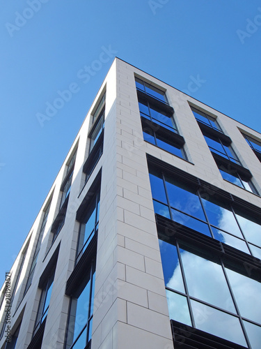 Εκτύπωση καμβά upwards view of the corner of a white modern office building with blue sky and c