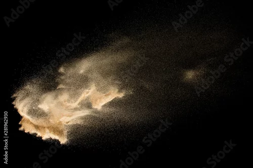 Obraz Dry river sand explosion isolated on black background. Abstract sand cloud.Brown colored sand splash against dark background.