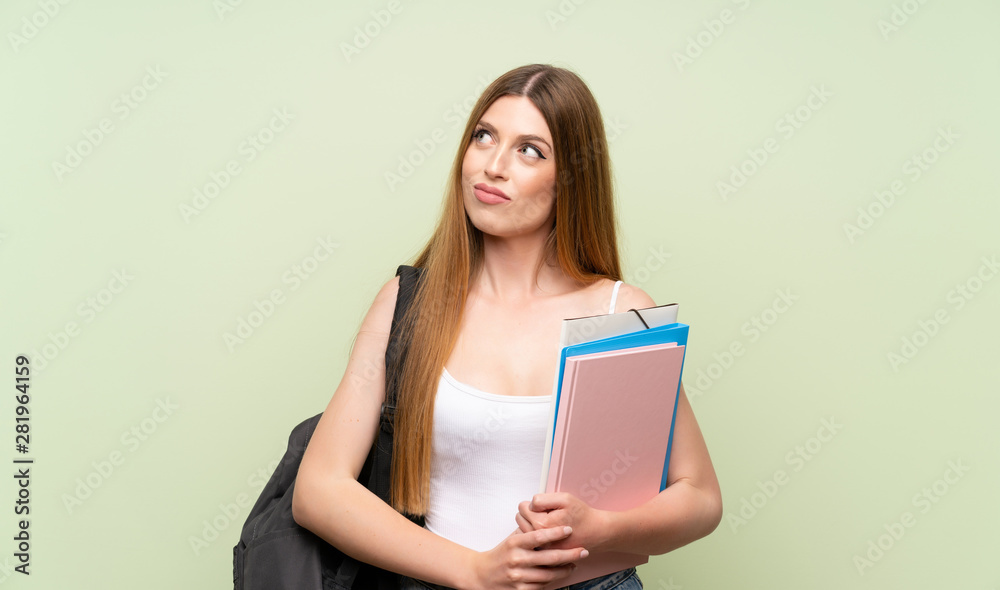 Young student woman over isolated green background standing and looking to the side Young student woman over isolated green background standing and looking to the side