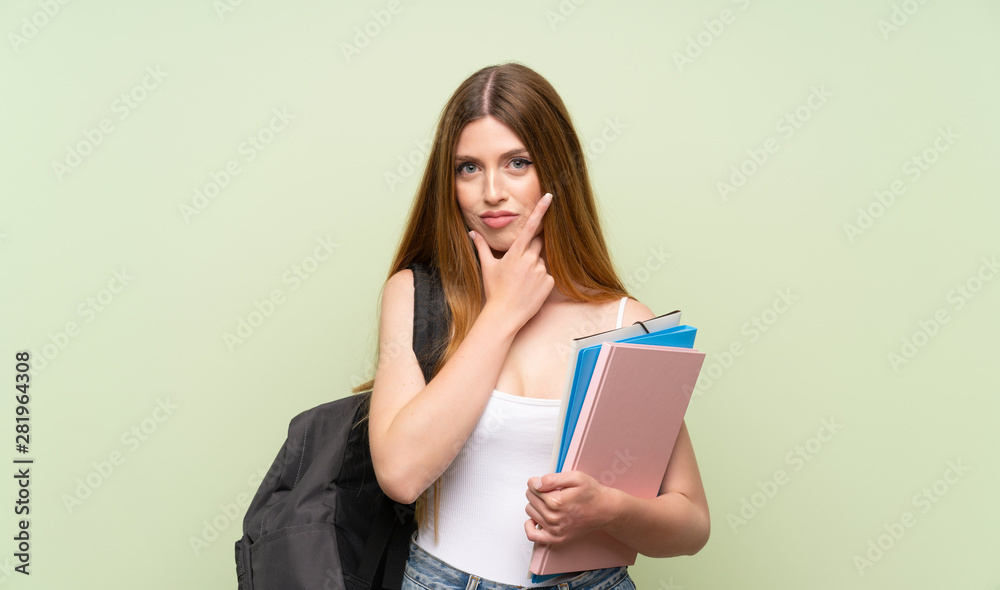 Young student woman over isolated green background thinking an idea