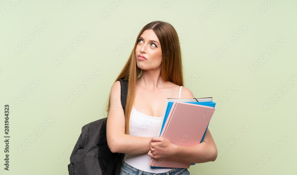 Young student woman over isolated green background thinking an idea