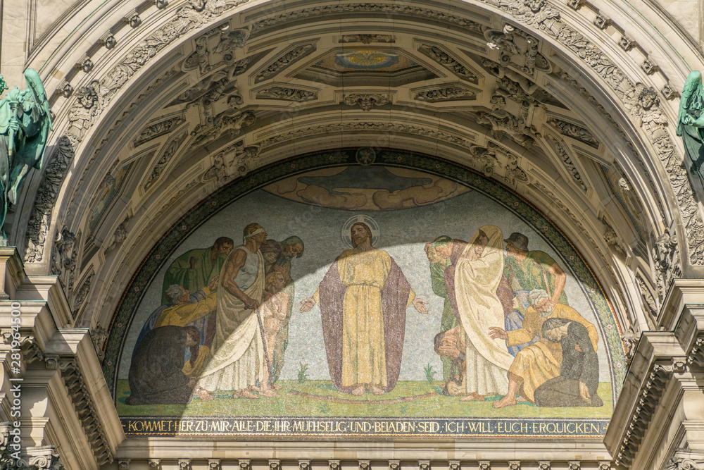 Obraz premium Antique religious mosaic art in front of the Lustgarten portraiting Jesus healing the sick at the facade of the Berliner Dom, the Berlin Evagelical Cathedral landmark