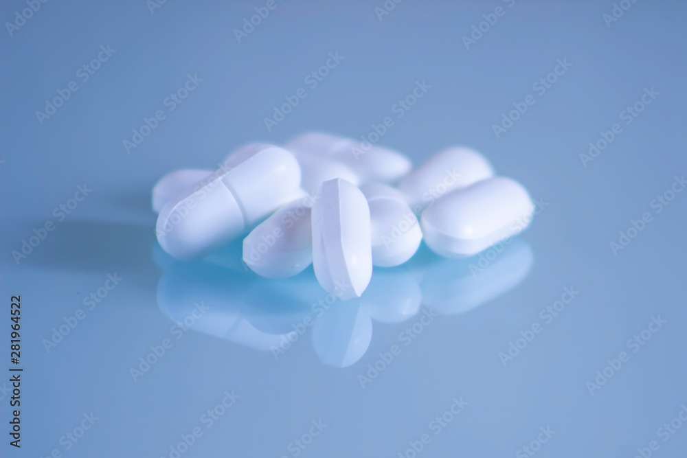 White Pills on blue background. Medical care and treatment. Medical theme. White Pills on blue background. Medical care and treatment. Medical theme.