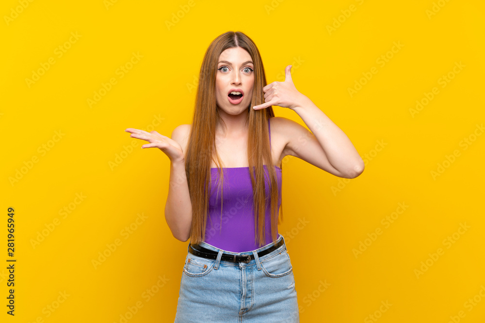 Young woman over isolated yellow background making phone gesture and doubting