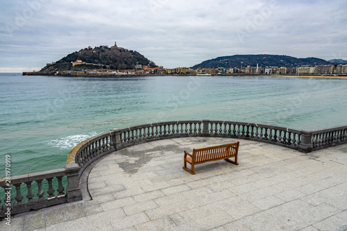 An empty bench in San Sebastian during winter season with a view on La Concha bay, Basque Country, Spain photo