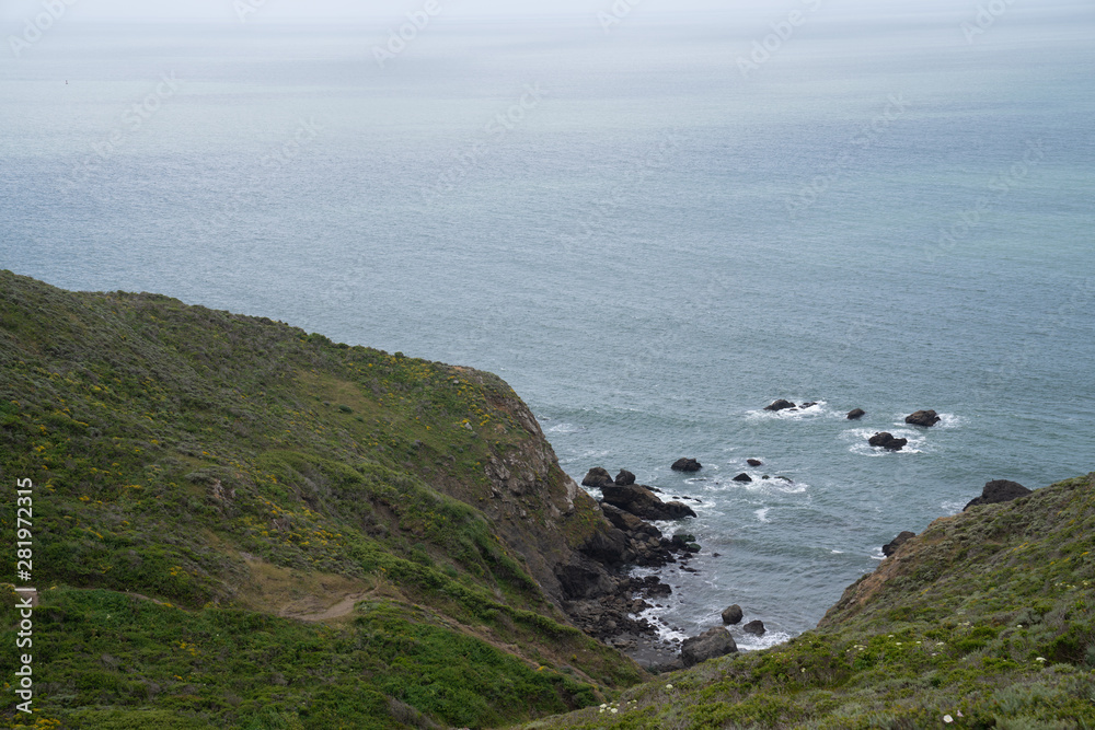 View from top of hills leading to rocky cove in the ocean View from top of hills leading to rocky cove in the ocean