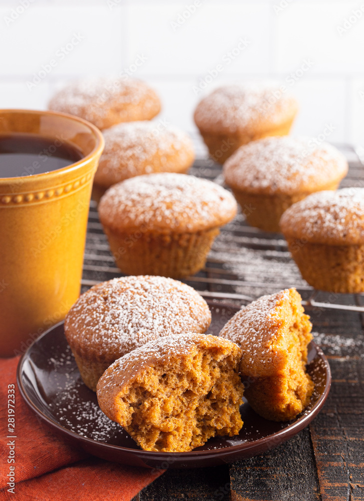 Pumpkin Spice Muffins Topped with Powdered Sugar on a Wooden Table