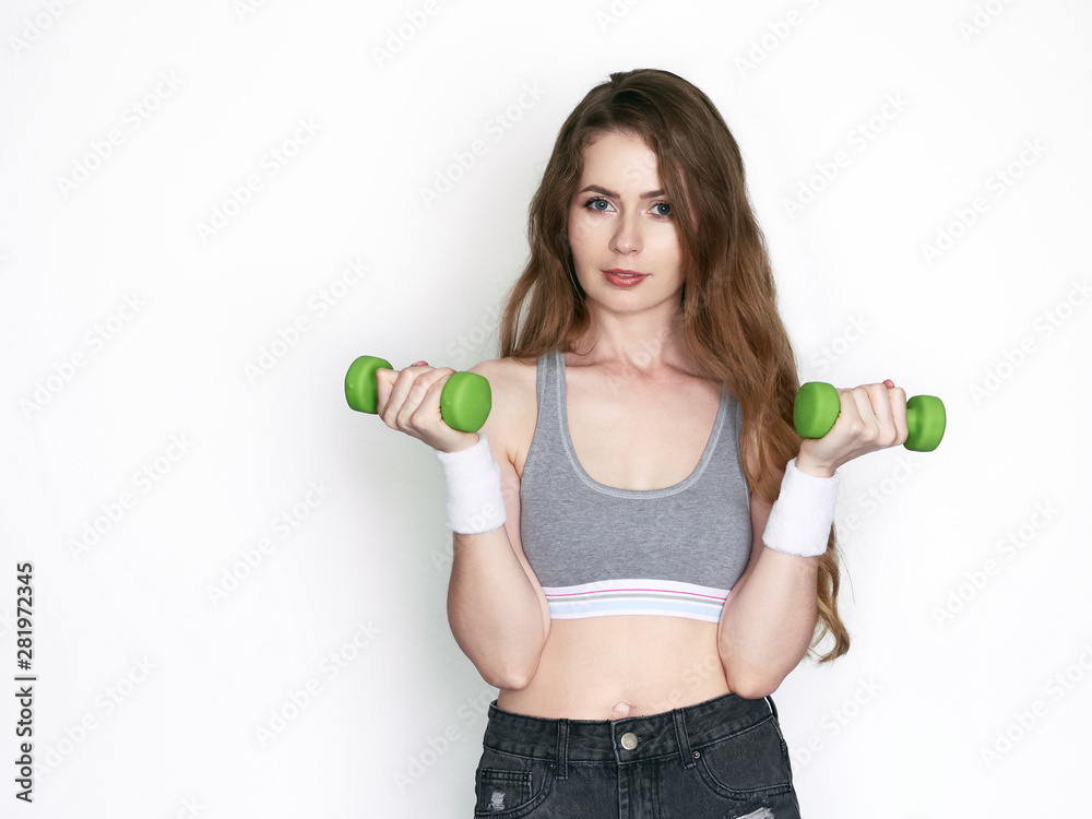 Young healthy beautiful blonde woman gorgeous long wavy hairstyle dressed grey sporty top having fun emotionally posing dumbbells misted gym flask cold water on white background Young healthy beautiful blonde woman gorgeous long wavy hairstyle dressed grey sporty top having fun emotionally posing dumbbells misted gym flask cold water on white background