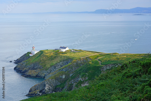 Photography View of green heather fields, the Baily Lighthouse and the Irish Sea seen from t