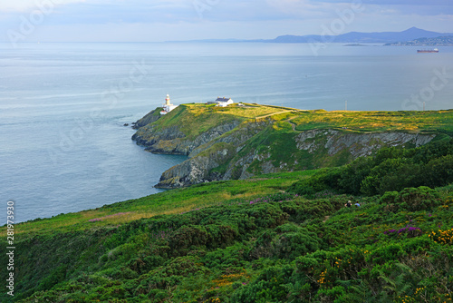 Canvas Print View of green heather fields, the Baily Lighthouse and the Irish Sea seen from t