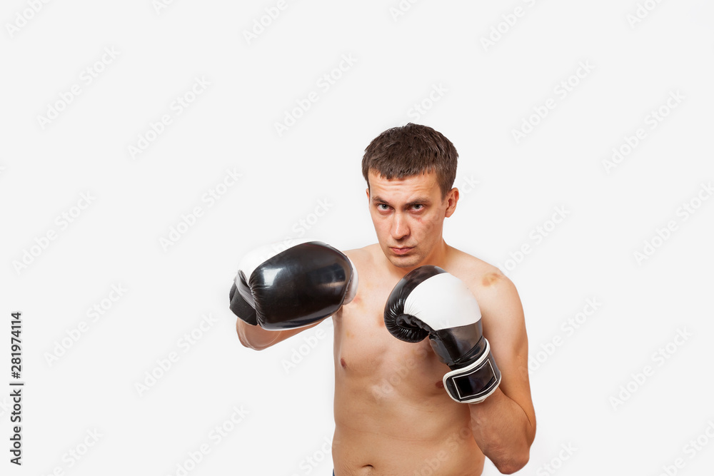A man in boxing gloves with bruises on his body and face stabs during a fight and boxing on a white isolated background A man in boxing gloves with bruises on his body and face stabs during a fight and boxing on a white isolated background