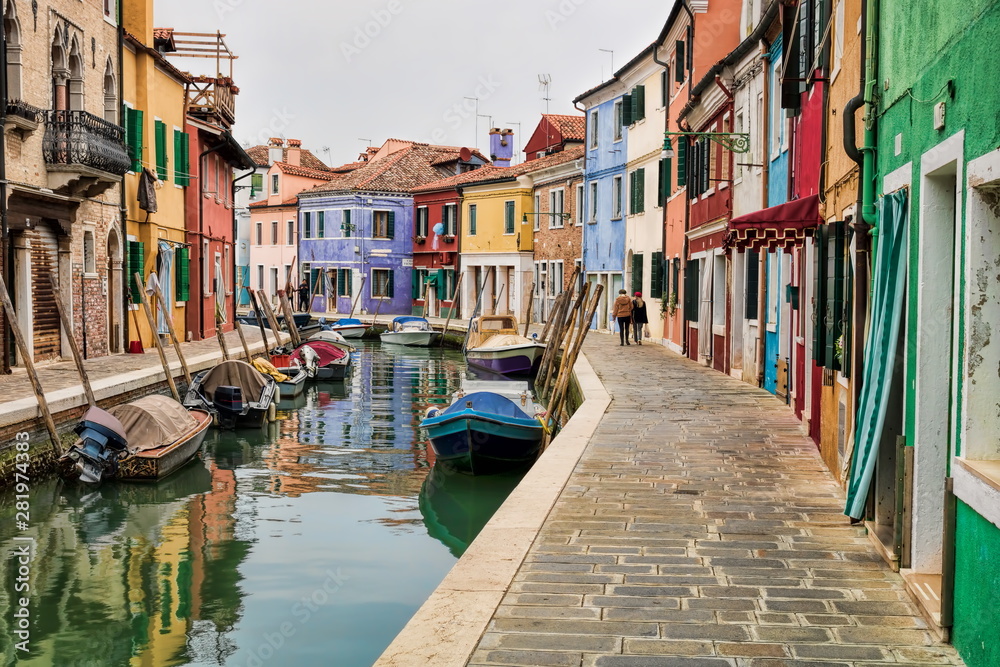 idyllischer kanal mit booten und bunten häusern in burano, italien