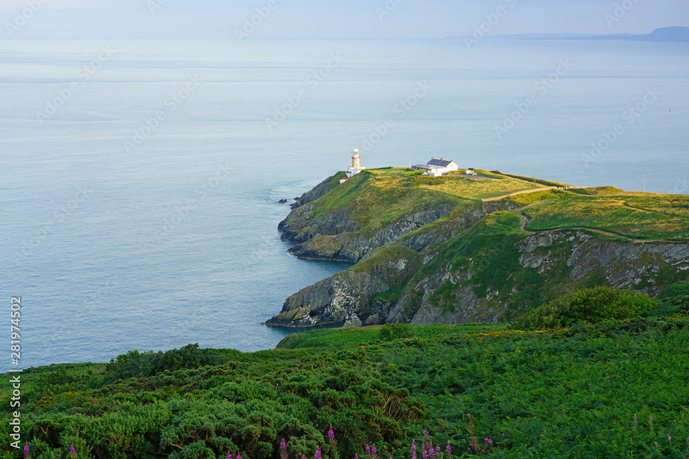 View of green heather fields, the Baily Lighthouse and the Irish Sea seen from the Howth Summit in Howth, near Dublin, Ireland