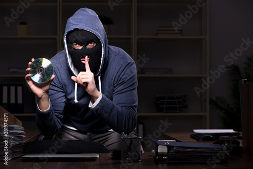 Male thief in balaclava in the office night time