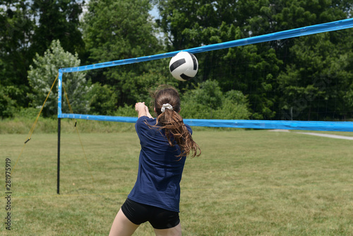 Girl setting volleyball near the net